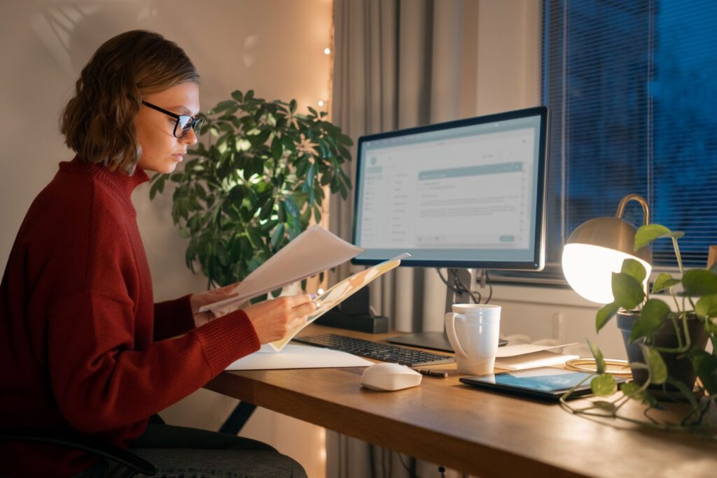 Woman working late with documents at night from home
